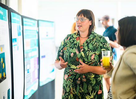 Scientist discussing a scientific poster with a colleague